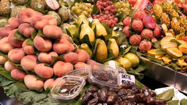 September 22, 2017 - Barcelona, Spain, Mercator de la Boqueria Food Market: a huge counter with tropical fruits, mango, passion fruit, kiwi, bananas — стоковое видео