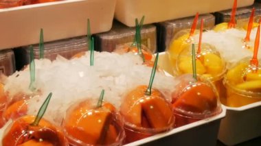 Meyve pazarının raflarda plastik bardaklarda farklı meyve karışımı