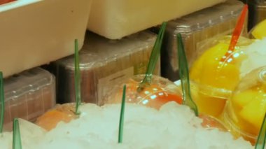 Meyve pazarının raflarda plastik bardaklarda farklı meyve karışımı