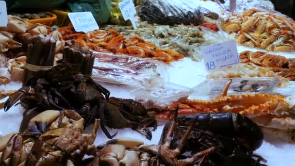 Mariscos moviendo camarones grandes langostas y cangrejos en el mercado de mostradores, Mariscos en el mercado La Boquería en Barcelona — Vídeos de Stock
