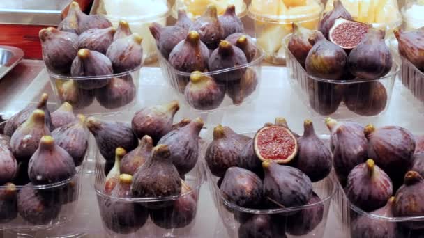 Тропические фруктовые инжиры на прилавке в пластиковой коробке стоят на льду — стоковое видео