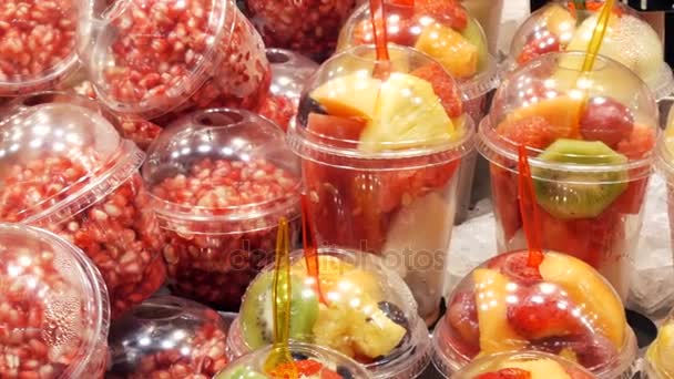 Frais fraîchement emballé dans un mélange en verre plastique de fruits pastèque, kiwi, poire, pomme, mangue, grenade, fraise gros plan — Video
