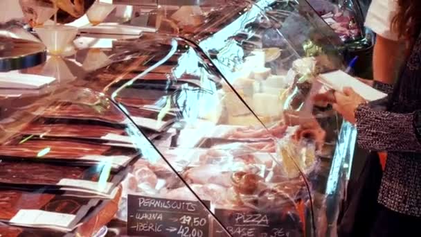 22 вересня 2017 - Барселона, Іспанія, Меркатор de la продовольчий ринок Бокерія: жінка з список продуктів на м'ясників магазин і вибирає продукцію — стокове відео