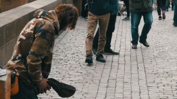 12 de setembro de 2017 - Praga, República Tcheca: O pobre homem implora esmolas nas ruas da cidade ao redor há muitas pessoas e ninguém dá nada, mendigo sentado na rua à espera de moedas — Vídeo de Stock