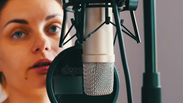 Hermosa chica da una entrevista en el micrófono del estudio — Vídeos de Stock
