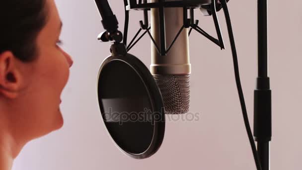 Młoda seksowna dziewczyna daje wywiad lub pisze mowy w mikrofon studio — Wideo stockowe
