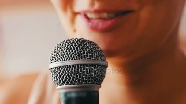 Schöne Mädchen sagen etwas in einem Handmikrofon — Stockvideo