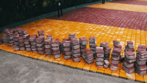 Azulejos de acera multicolores en el parque infantil se encuentra en el suelo listo para la colocación — Vídeos de Stock