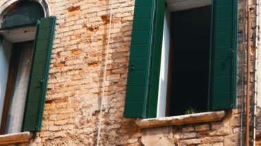 Venedik, İtalya, 7 Eylül 2017: sözde Venedik veya İtalyan mimarisi, güzel vintage cam pencere eşiği ile yeşil Panjur ve kırmızı tuğla duvar