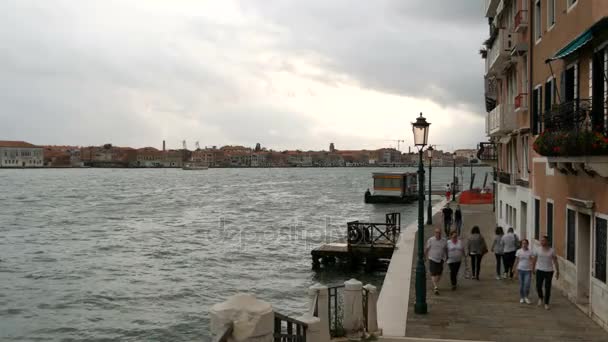 Venedig, Italien, 7 September 2017: En vacker utsikt över Venedig vallen på kanalen Gande, vatten som slår mot stranden, längs vilken människor promenader — Stockvideo
