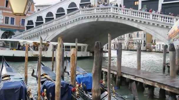 Venedik, İtalya, 7 Eylül 2017: Güzel siyah gondol yaldızlı rakamları ile bir dünya ünlü Rialto Köprüsü altında park etmiş standı — Stok video