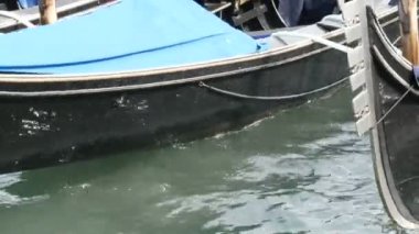 Güzel siyah gondol stand ve Grand Canal Venedik dalgaları devam et