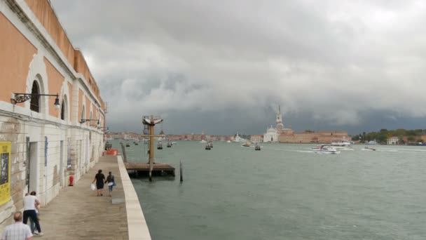 VENECIA, ITALIA, 7 DE SEPTIEMBRE DE 2017: Una hermosa vista del terraplén de Venecia en el Canal de Gande, cuyas aguas están golpeando contra la orilla, a lo largo del cual la gente está paseando — Vídeos de Stock