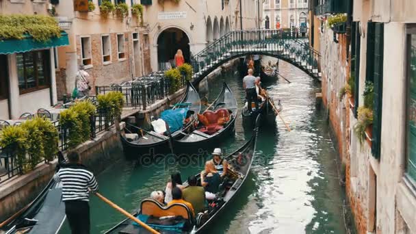 VENISE, ITALIE, 7 SEPTEMBRE 2017 : Belles gondoles et gondoles avec des touristes sur eux conduisent à travers l'ancien canal vénitien — Video