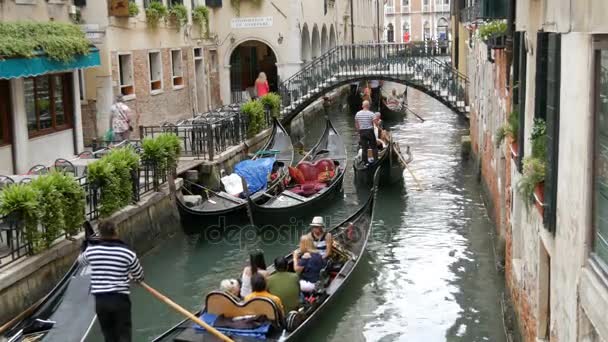VENECIA, ITALIA, 7 DE SEPTIEMBRE DE 2017: uno de los pintorescos canales venecianos en los que las góndolas y los gondoleros dirigen a turistas enrollados — Vídeo de stock