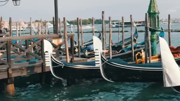 VENICE, ITÁLIA, SETEMBRO 7, 2017: Gôndola veneziana coberta de pano azul enquanto atracava no canal em Veneza Itália, Noses ancorado gôndolas ordenadamente em pé em uma fileira — Vídeo de Stock