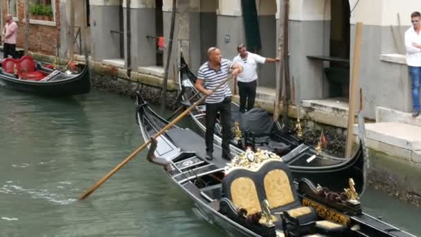 VENECIA, ITALIA, 7 DE SEPTIEMBRE DE 2017: Hermosas góndolas y gondoleros con turistas en ellos conducen a través del antiguo canal veneciano — Vídeos de Stock