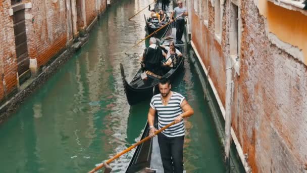 VENECIA, ITALIA, 7 DE SEPTIEMBRE DE 2017: Hermosas góndolas y gondoleros con turistas en ellos conducen a través del antiguo canal veneciano — Vídeos de Stock