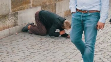 12 Eylül 2017 - Prag, Çek Cumhuriyeti: zavallı adam sorar para ya da sadaka ile Prag Charles Köprüsü üzerinde geçen insanlar, uzanmış bir el için