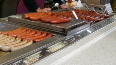 Bir kadın satıcısı sosis ızgara, Prag'ın merkezi sokak gıda, sokak tepsi tezgahın üstünde farklı sosis çeşitli ızgara