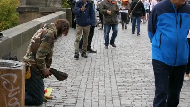 September 12, 2017 - Prague, Czech Republic: The poor man begs alms in the streets of the city around there are many people and no one gives anything, Beggar sitting in the street waiting for coins — стоковое видео