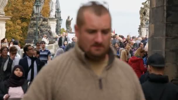 12 september 2017 - Prag, Tjeckien: Skara människor vandrar längs Karlsbron i Prag tidigare berömda statyer och skulpturer. Berömda historiska bron som korsar floden Moldau — Stockvideo