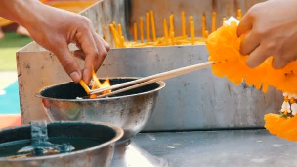 Människor lätt doftande trollstavar för lycka och vaxljus från skål med levande eld. Buddhistiska religionen. — Stockvideo