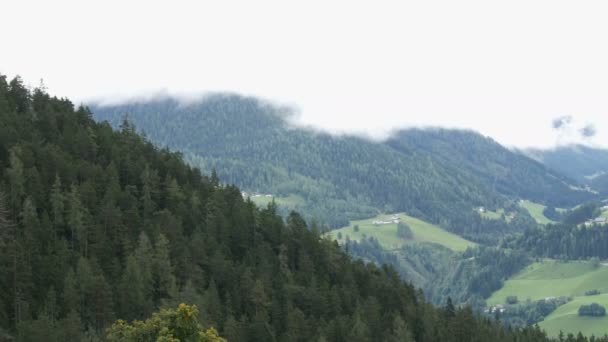 Vista panorámica del valle montañoso de los Alpes austríacos. Muchas casas en valle rodeadas de montañas. Casas blancas e iglesia, prados verdes. Hermoso pueblo pintoresco — Vídeo de stock
