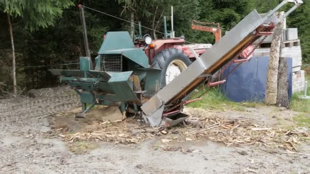 Petite scierie du village. Un tracteur et un support de scie dans les bois, le long des troncs coupés et emballés — Video