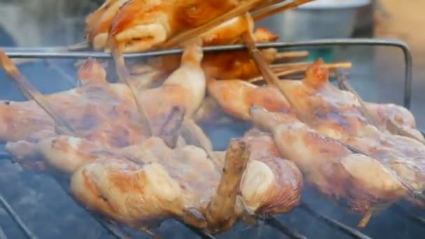 Celé kuře gril jatečně upravené tělo navlečené na dřevěnou hůl, grilování na grilu. Pouliční prodavači Thajsko — Stock video