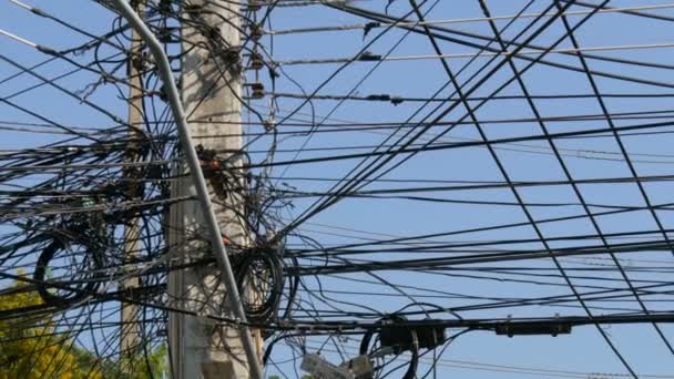 Tangled bundles of overhead wires. Electricity system on streets of Pattaya, Thailand. Tangle of wires on overloaded utilities pole in Thailand wire level pan — Stock Video