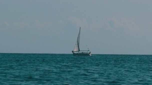 Belo veleiro branco no horizonte, flutuando em um mar — Vídeo de Stock