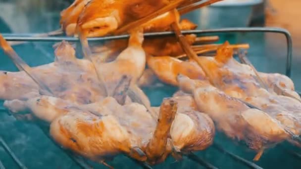 Bütün tavuk karkas ızgara ızgara ızgara ahşap çubuk üzerinde sinirli. Sokak gıda Tayland — Stok video