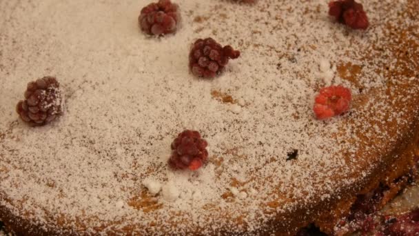 Woman sprinkles with powdered sugar a homemade brown pie — Stock Video