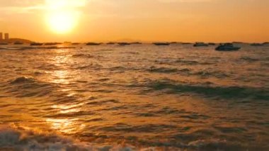 Pattaya, Tayland - 25 Aralık 2017: Bir güzel kırmızı günbatımı Dağları nın zemin karşı sahil üzerinde. Denizdeki dalgaların kıyıya akşam yendi. Denizin üzerinde zevk tekneler