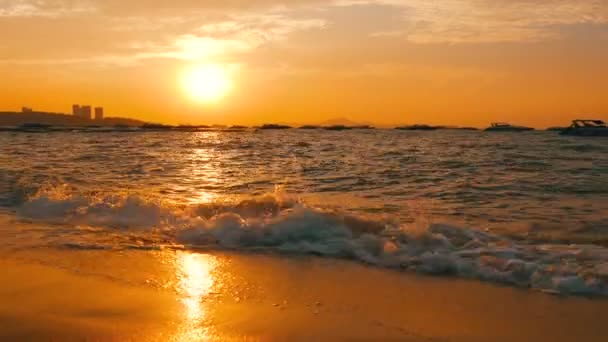 Puesta de sol muy hermosa en la orilla del mar. Playa de arena y olas que golpean en la playa — Vídeo de stock