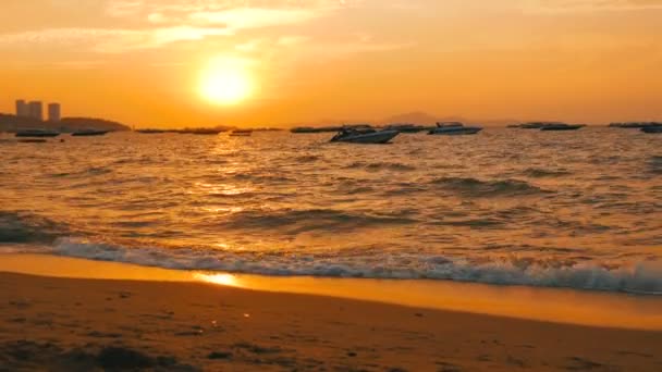 PATTAYA, THAÏLANDE - 25 DÉCEMBRE 2017 : Un coucher de soleil rouge pittoresque sur le littoral dans le contexte des montagnes. Les vagues de la mer battent contre le rivage dans la soirée. Bateaux de plaisance sur la mer — Video