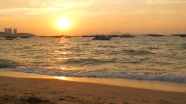 Pattaya, Tayland - 25 Aralık 2017: Bir güzel kırmızı günbatımı Dağları nın zemin karşı sahil üzerinde. Denizdeki dalgaların kıyıya akşam yendi. Denizin üzerinde zevk tekneler