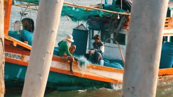 Pattaya, Thailand - 25 December 2017: Oude houten boot op het dok. Vissers uitzoeken van de netwerken met een vangst op de pier — Stockvideo