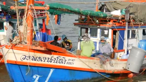 PATTAYA, THAILAND - 25 ДЕКАБРЯ 2017: Old wooden boat on the dock. Рыбаки разбирают сети с уловом на пирсе — стоковое видео