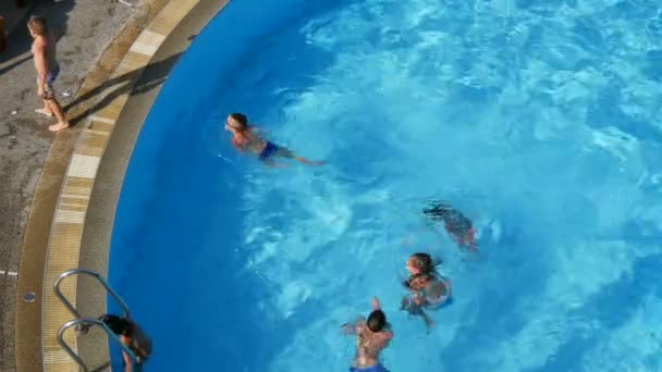 PATTAYA, TAILANDIA - 25 DE DICIEMBRE DE 2017: Los niños nadan en una piscina azul clara desde arriba — Vídeos de Stock