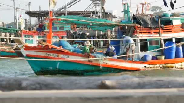 PATTAYA, TAILÂNDIA - DEZEMBRO 25, 2017: Velho barco de madeira na doca. Pescadores resolver as redes com uma captura no cais — Vídeo de Stock