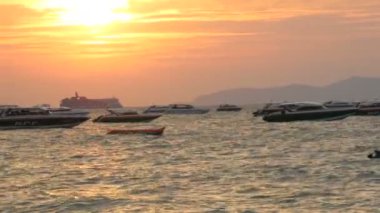 Pattaya, Tayland - 25 Aralık 2017: Bir güzel kırmızı günbatımı Dağları nın zemin karşı sahil üzerinde. Denizdeki dalgaların kıyıya akşam yendi. Denizin üzerinde zevk tekneler