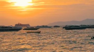 Pattaya, Tayland - 25 Aralık 2017: Bir güzel kırmızı günbatımı Dağları nın zemin karşı sahil üzerinde. Denizdeki dalgaların kıyıya akşam yendi. Denizin üzerinde zevk tekneler