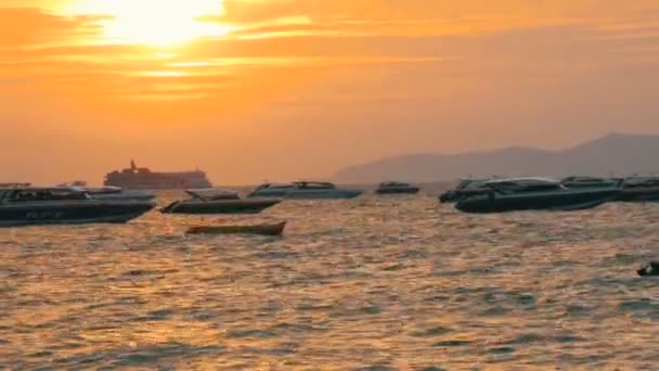 芭堤雅, 泰国-2017年12月25日: 在山的背景下, 海边风景如画的红色日落。海浪在傍晚拍打着岸边。海上游乐艇 — 图库视频影像