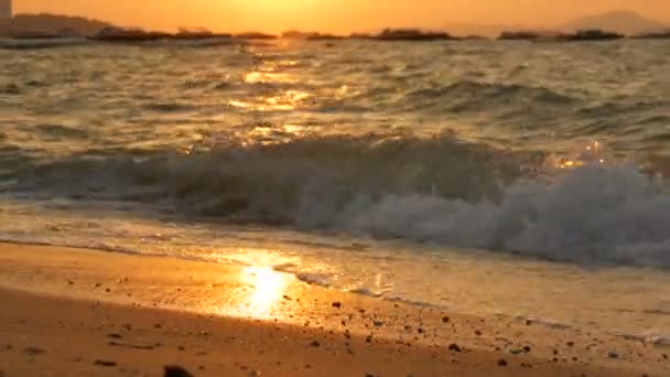 Beleza impressionante de um pôr-do-sol vermelho na praia. Ondas com batida de espuma na praia de areia na Tailândia — Vídeo de Stock