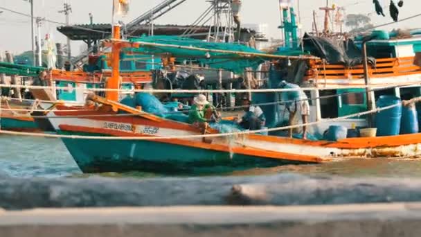 Pattaya, thailand - 25. dezember 2017: altes hölzernes boot auf dem dock. Fischer sortieren die Netze mit einem Fang am Steg — Stockvideo