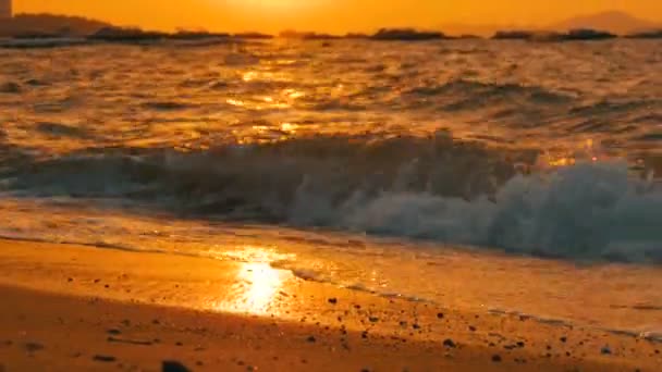 Puesta de sol muy hermosa en la orilla del mar. Playa de arena y olas que golpean en la playa — Vídeos de Stock