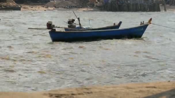 Pequeños barcos de pesca navegan a lo largo del exuberante mar en olas. Pescadores capturan peces en el mar — Vídeo de stock