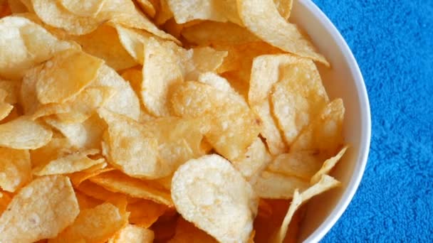 Beautiful female hands taking potato chips from huge plate, close up view — Stock Video